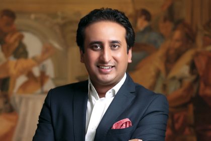 Rahul Chaudhary CEO of CG Hospitality standing in front of a hotel model